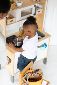 young child playing with play kitchen