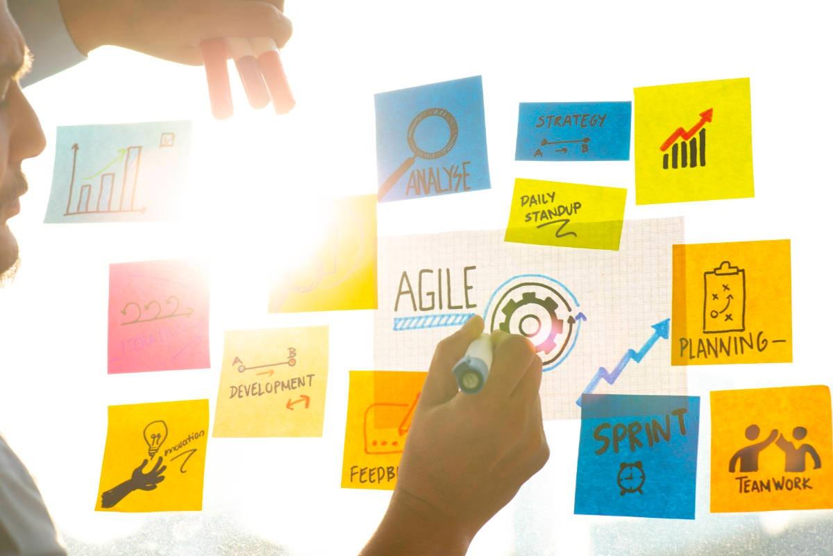 A man brainstorms on a whiteboard using the agile method of working