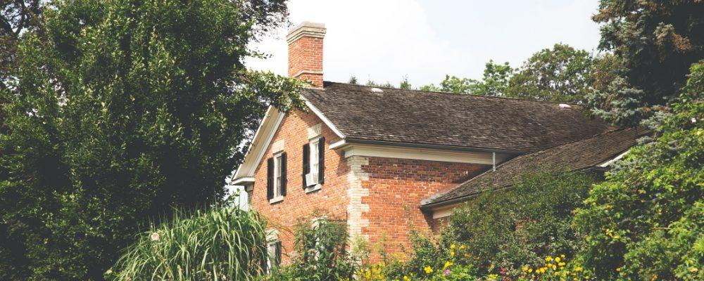 A red brick country house surrounded by trees