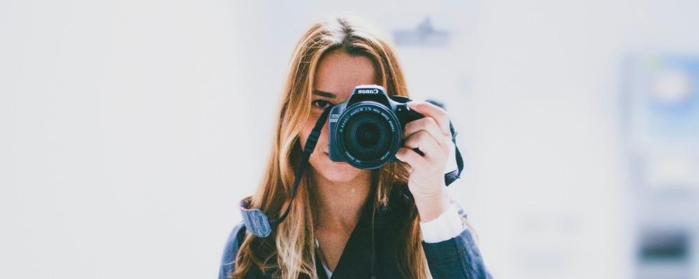 A female photographer taking a photo with a Canon EOS camera