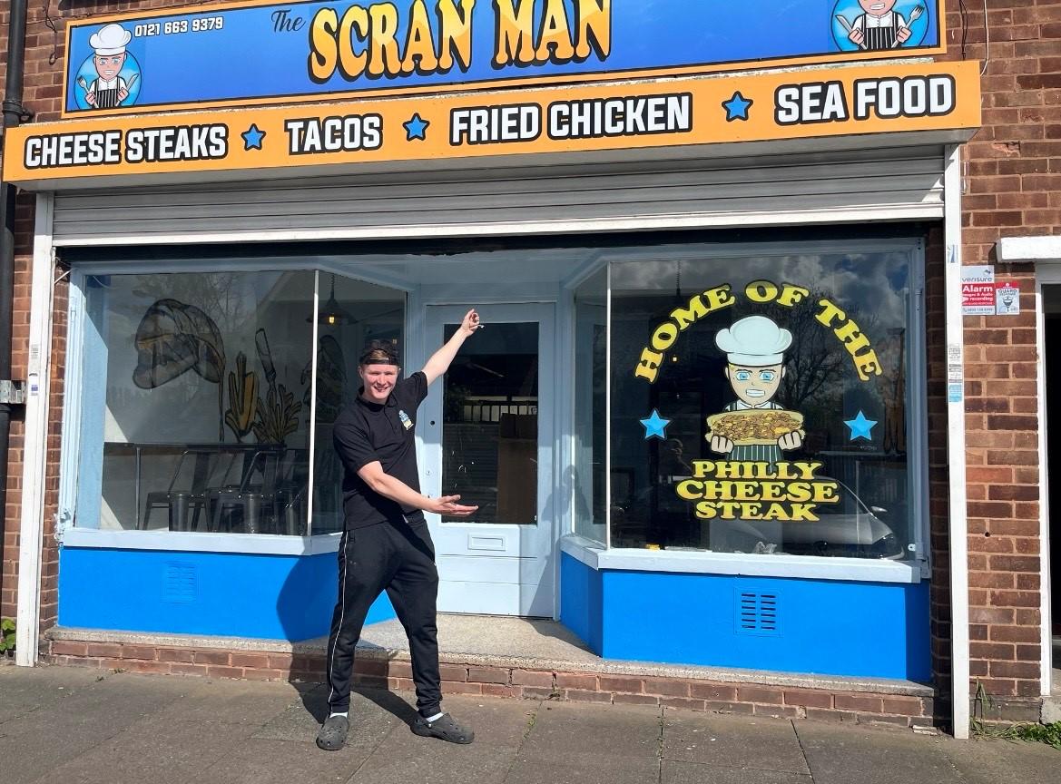 Image of business owner in front of his shop The Scran Man