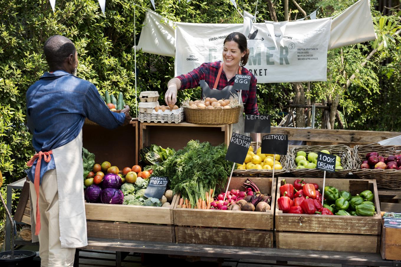 Two people preparing a greengrocers stall