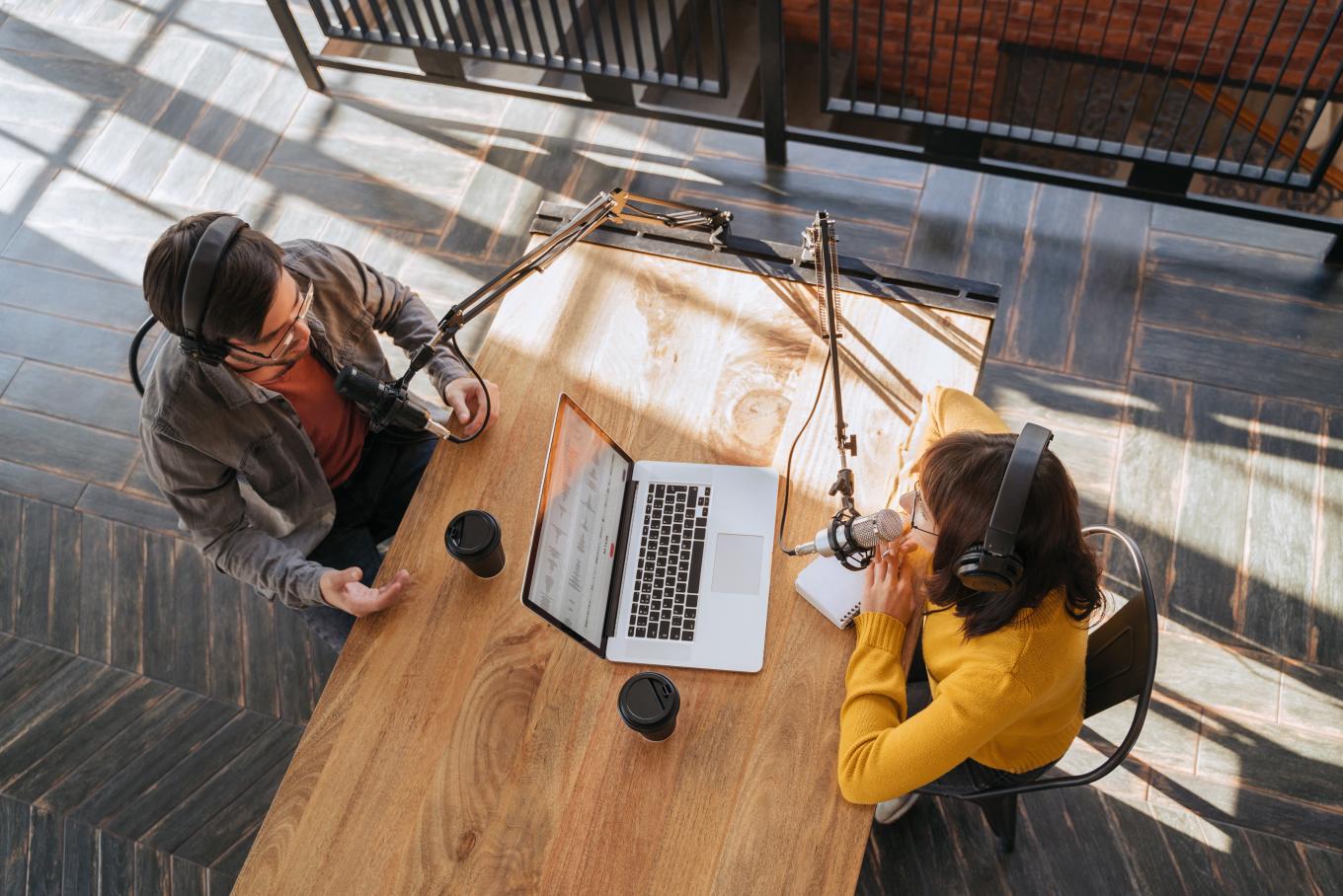 Image looking down at a desk, a man and woman either side. One is the interviewer, the other the interviewee