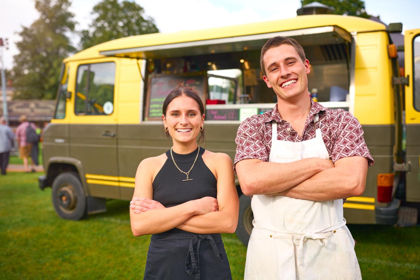 A male and female couple standing in front of a bougie style food truck